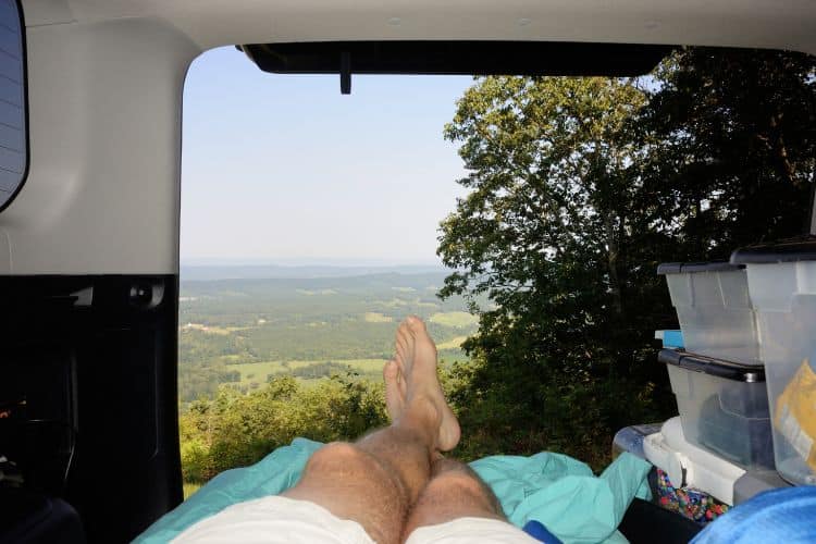 Relaxing in SUV car camping overlooking valley