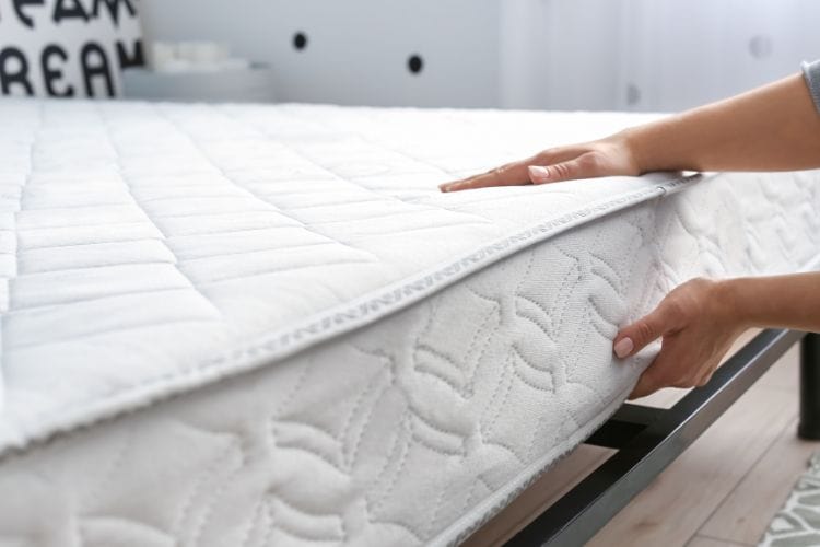 Woman Putting Soft mattress on bed frame