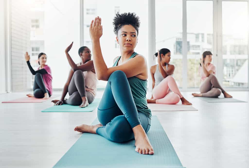 Fitness, yoga class and stretching exercise with women together for health and wellness. Instructor and diversity group in pilates studio for holistic workout, mental health and balance for zen mind