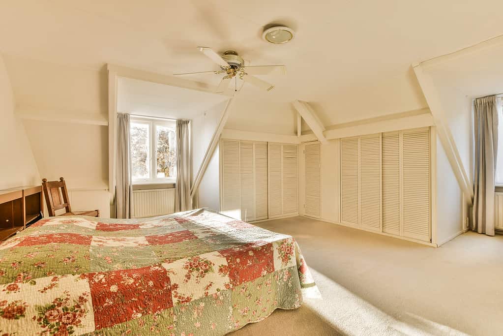 a large bedroom with a bed and a ceiling fan