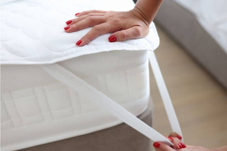 Woman Putting Mattress topper in bed